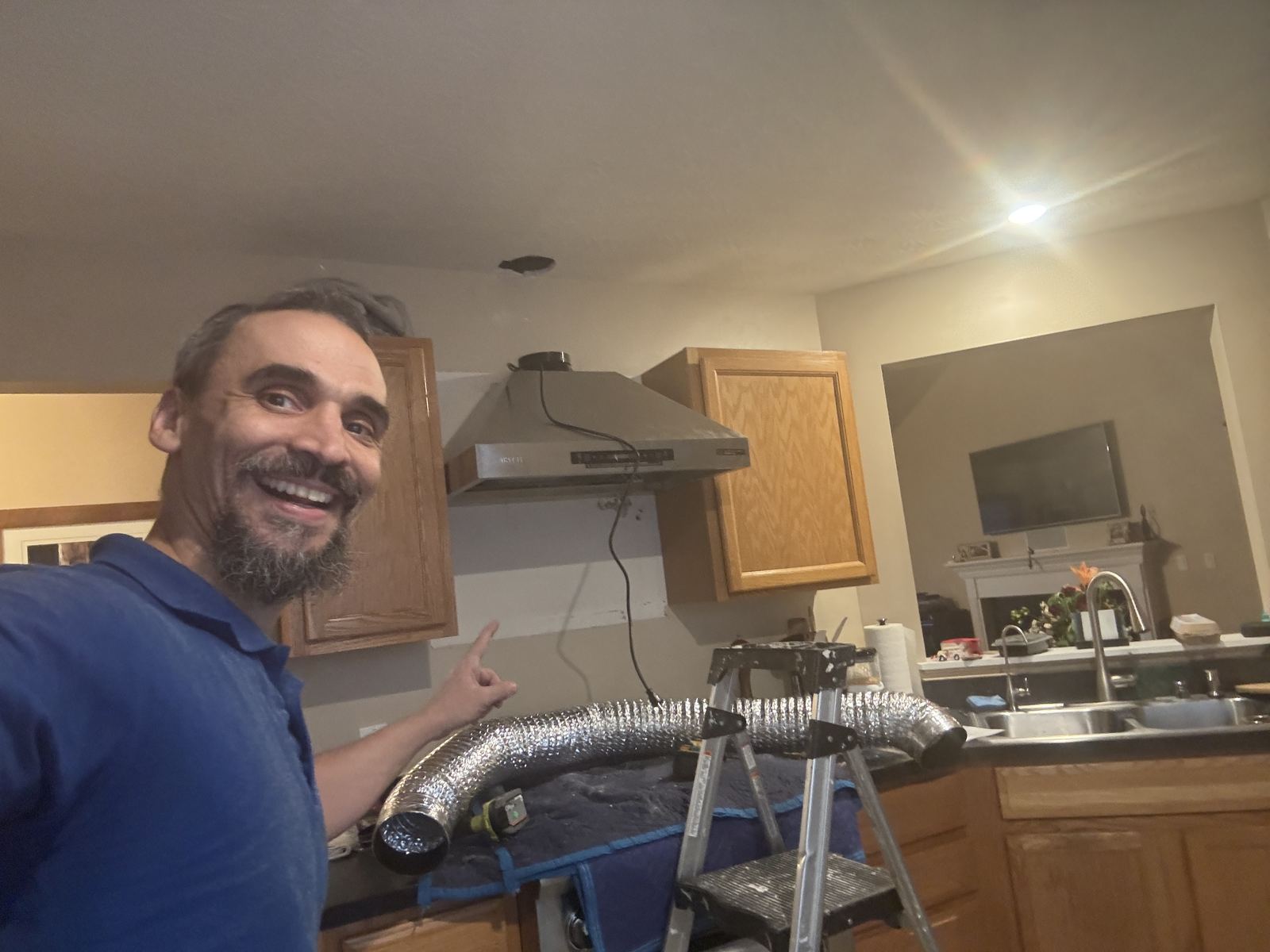 Range hood install in progress with flexible duct run to the ceiling
