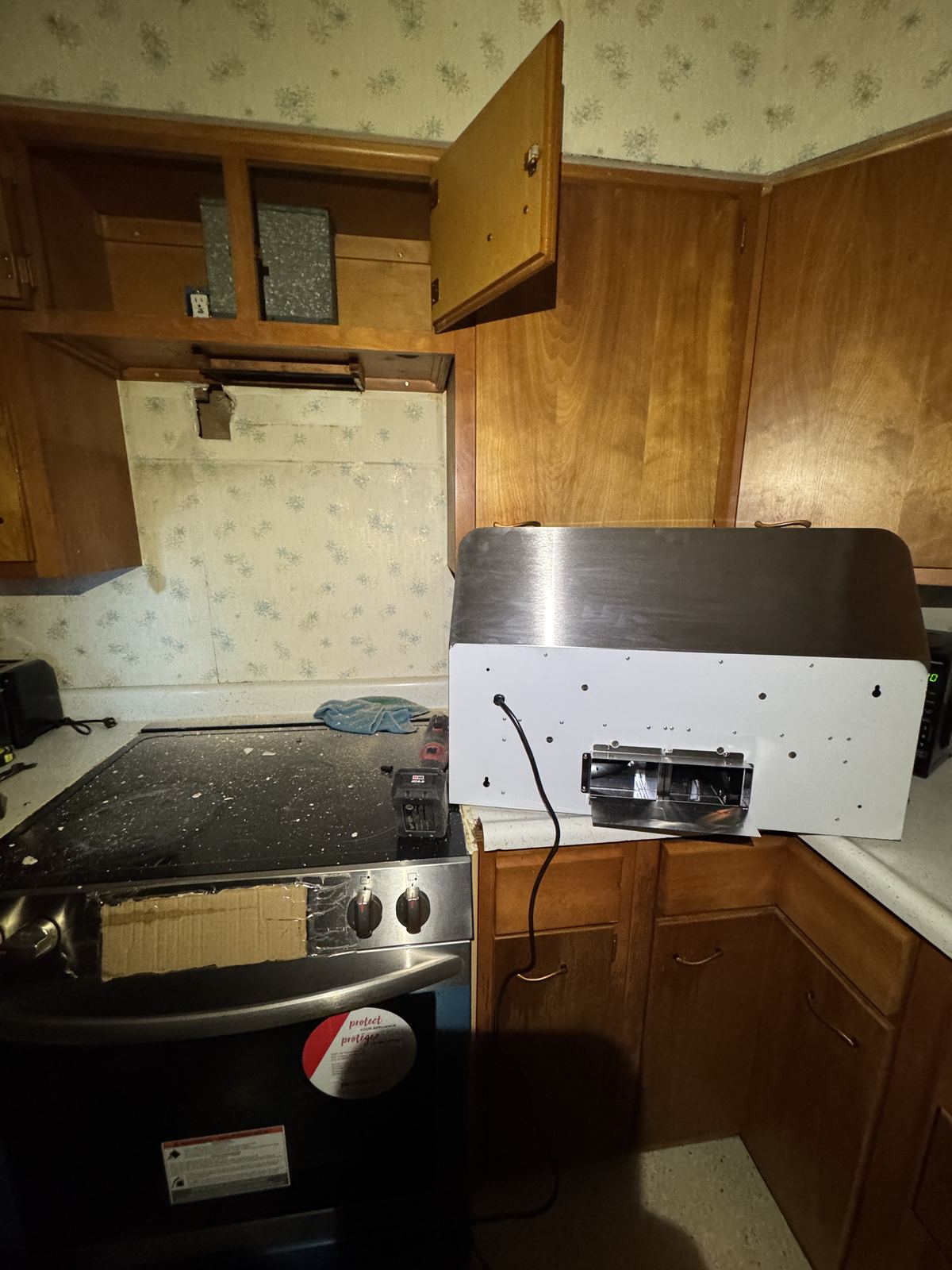 Old range hood removed and new hood unboxed for installation