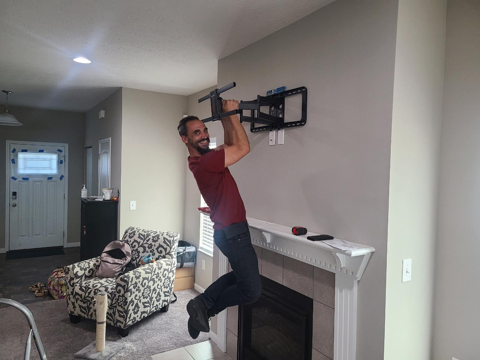 Strength test hanging from a newly installed TV wall mount