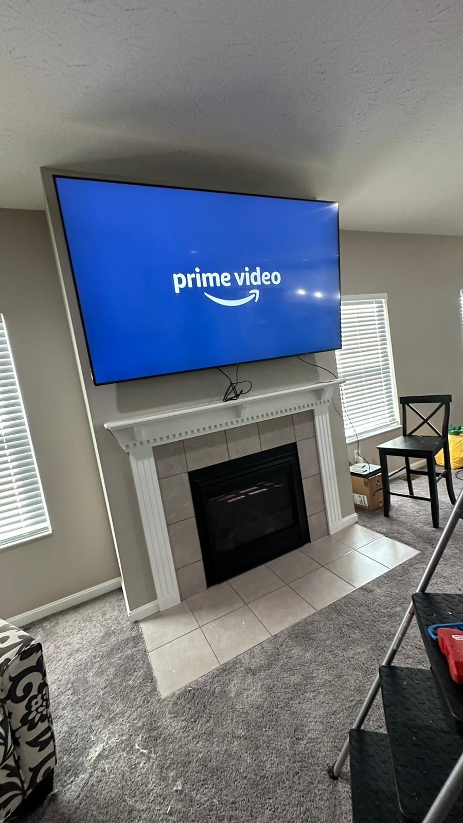 Large TV mounted over a fireplace with wiring hidden
