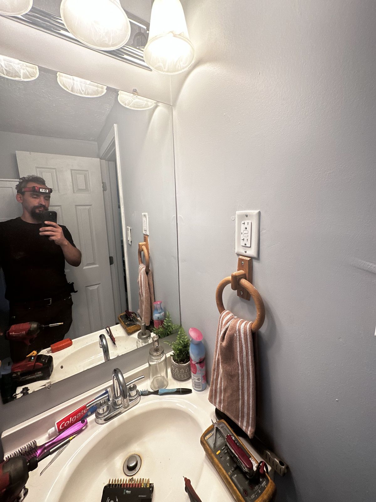 Gabriel in a bathroom mirror after an outlet and switch install