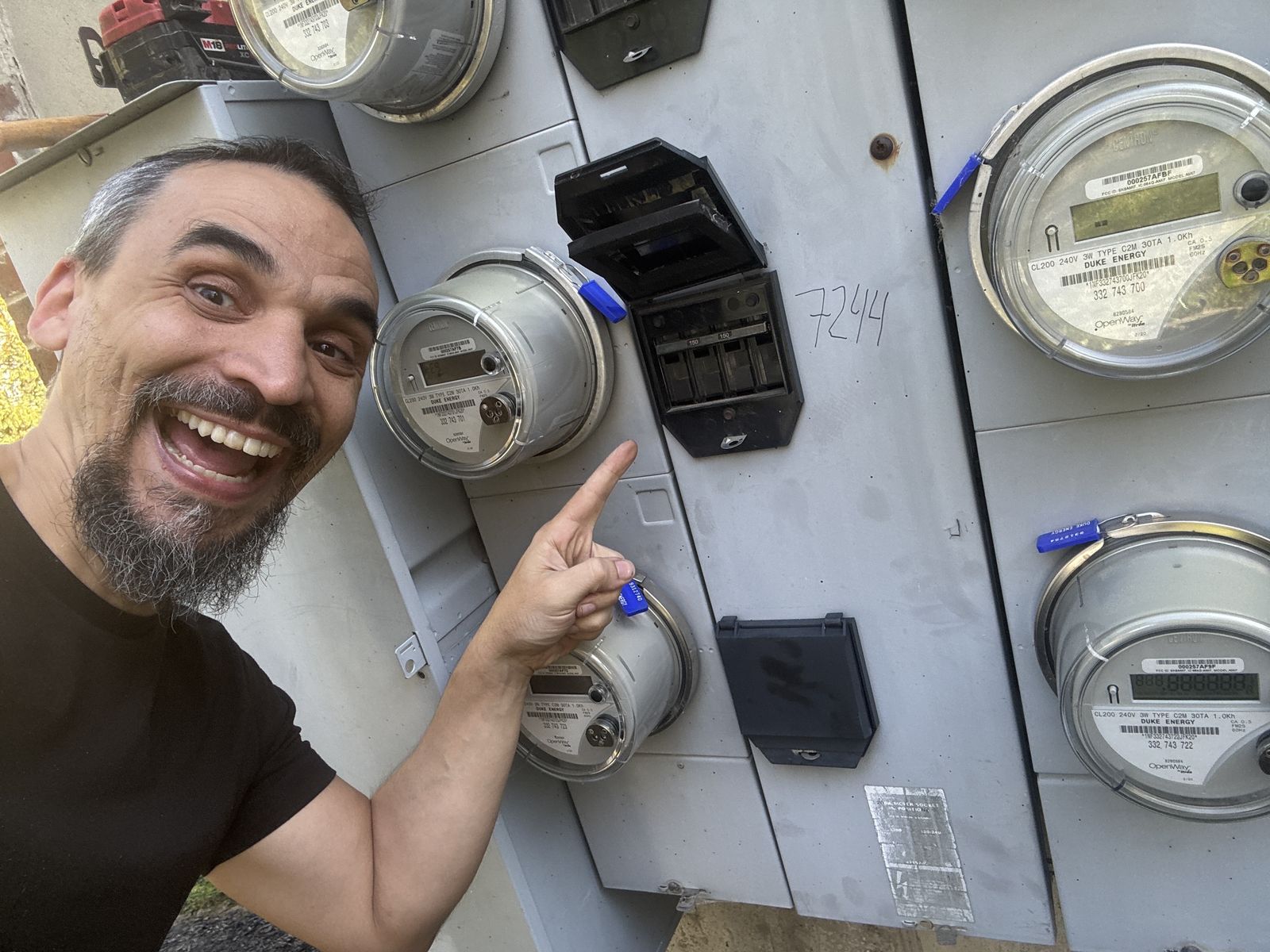 Gabriel pointing to an indoor electric meter bank