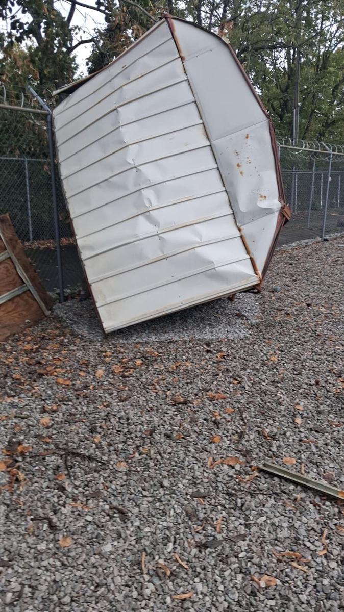 Damaged metal shed being cleared out for haul-away