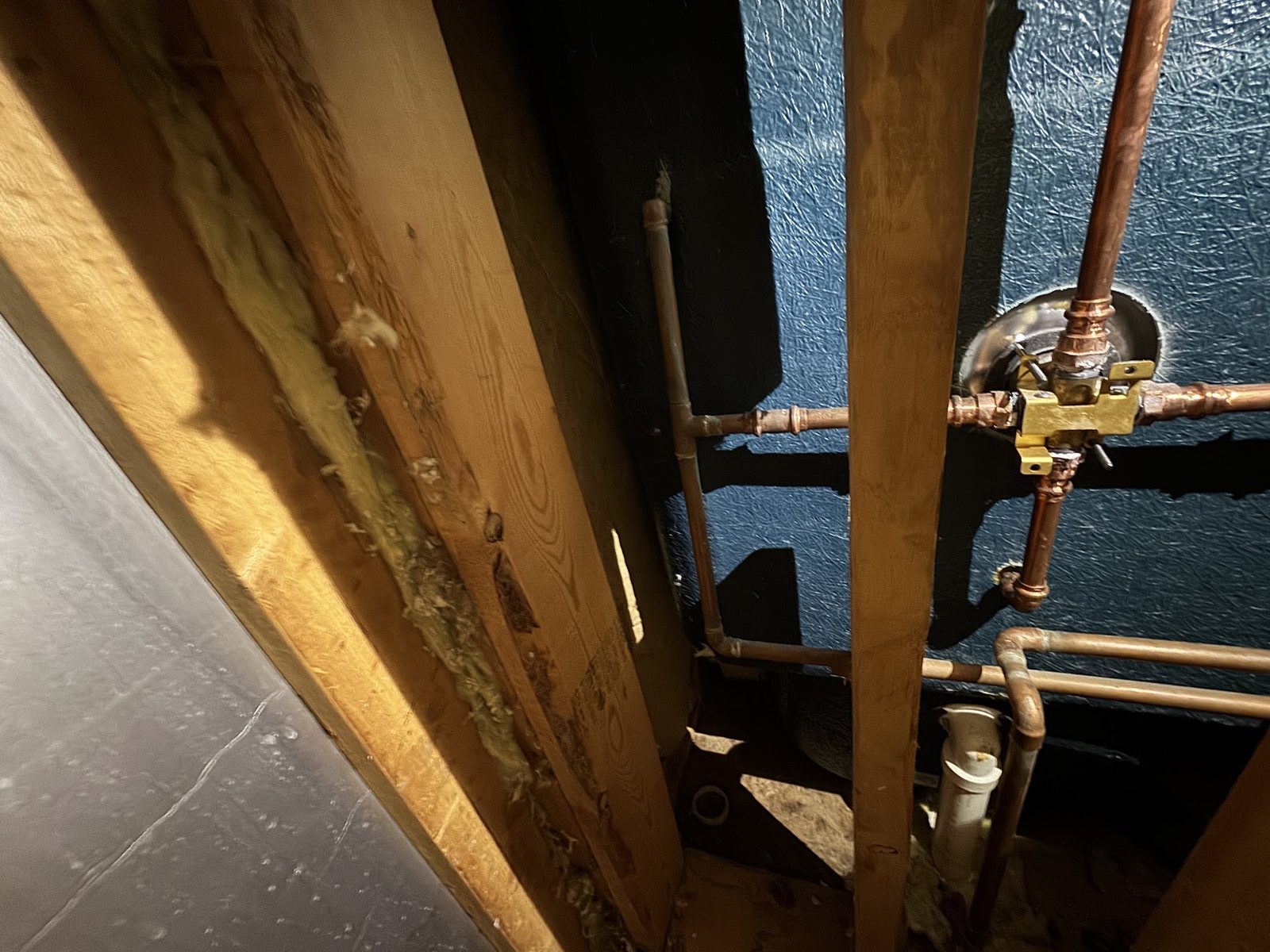 Copper supply pipes and shut-off valves opened up in the wall