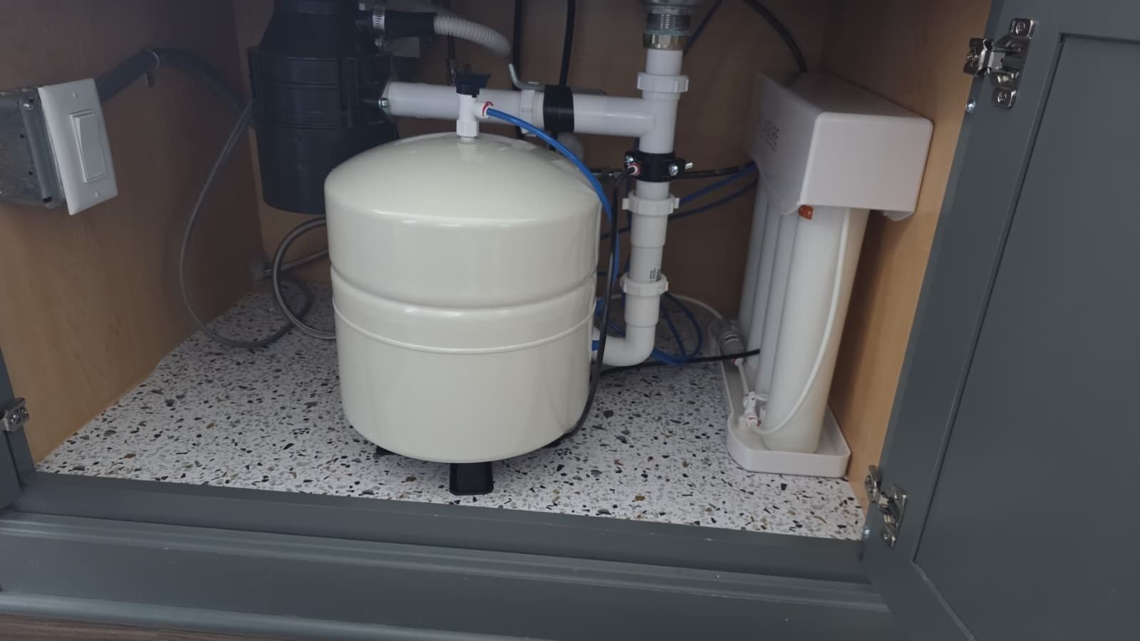 Reverse osmosis tank and filters installed under a kitchen island sink by Gabriel, Your Job Done Now