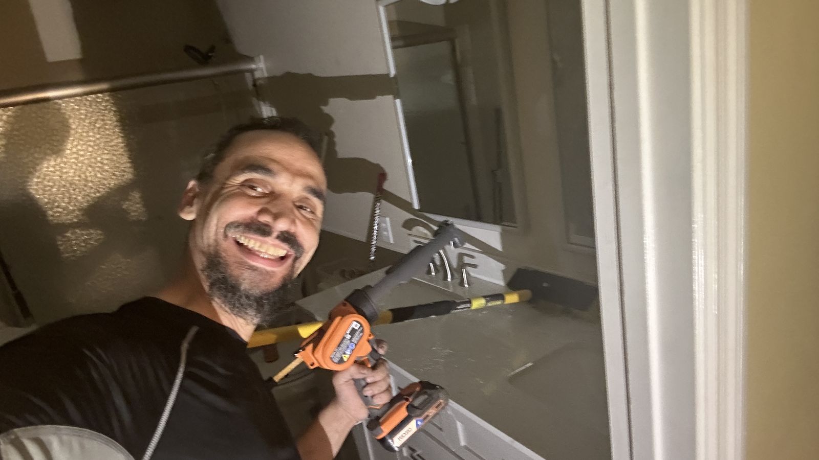 Working on a shower valve and fixtures with drill and level