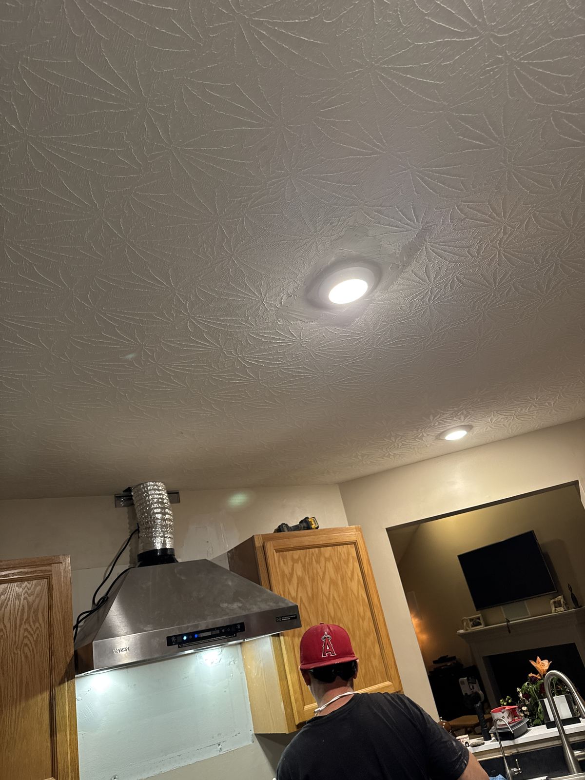 Finished stainless chimney range hood with LED lights over the stove