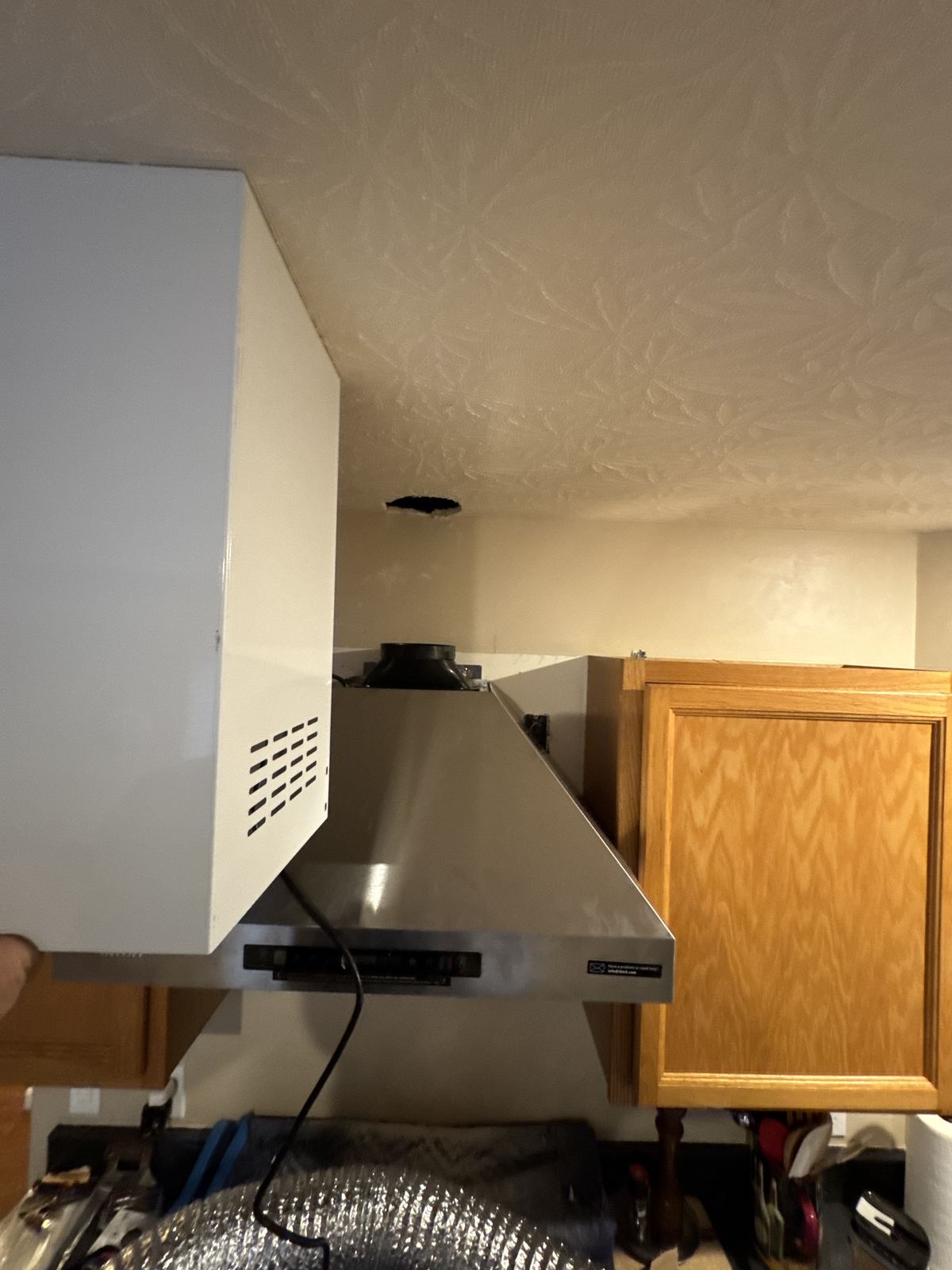 Stainless chimney range hood mounted and ready for the duct cover