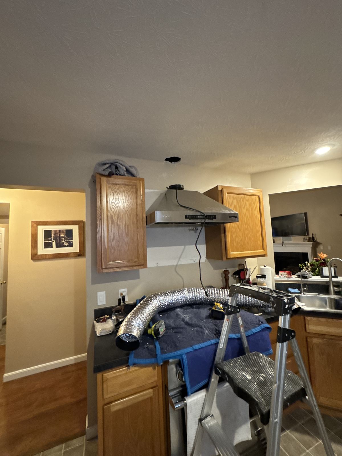 Kitchen set up for a range hood installation, counters protected