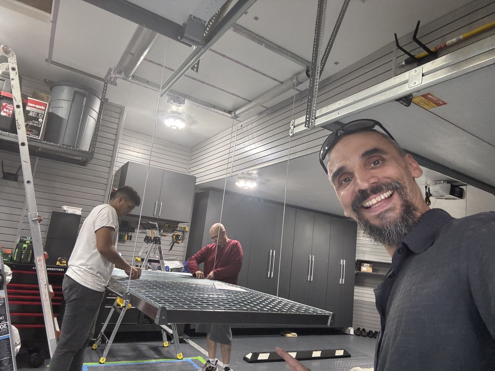 Gabriel in a garage after installing ceiling lights