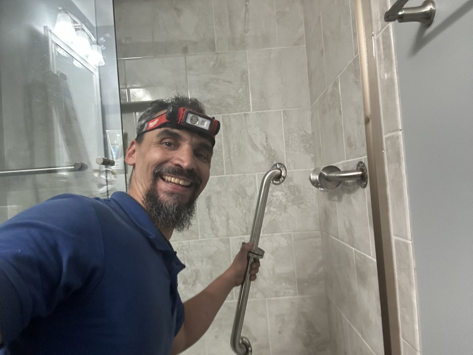 Stainless grab bar mounted next to the shower valve